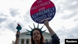 Žena drži natpis kojim se zagovara pravo na abortus ispred Vrhovnog suda, april 2024. (REUTERS/Evelyn Hockstein)
