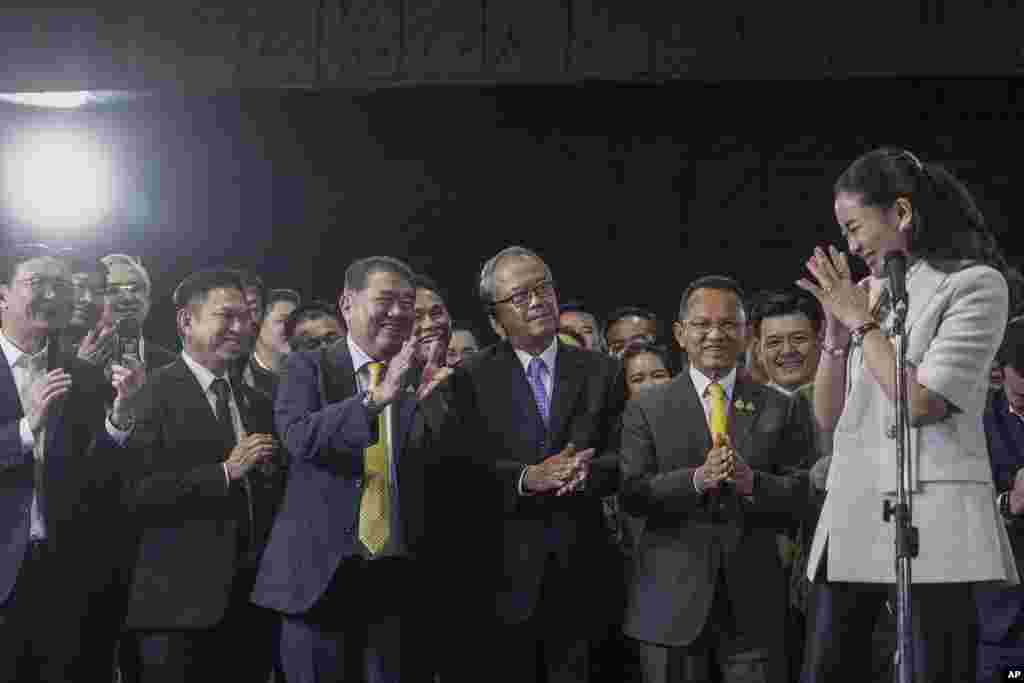 Thailand's Prime Minister-designate Paetongtarn Shinawatra, right, gestures to members of Pheu Thai party as she talks to reporters during a press conference at Pheu Thai party headquarters in Bangkok, Thailand.