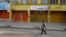 FILE: A person walks in front of closed shops as traders lock up their stores in protest of Ghana's worsening economic conditions in Accra, Ghana October 19, 2022.