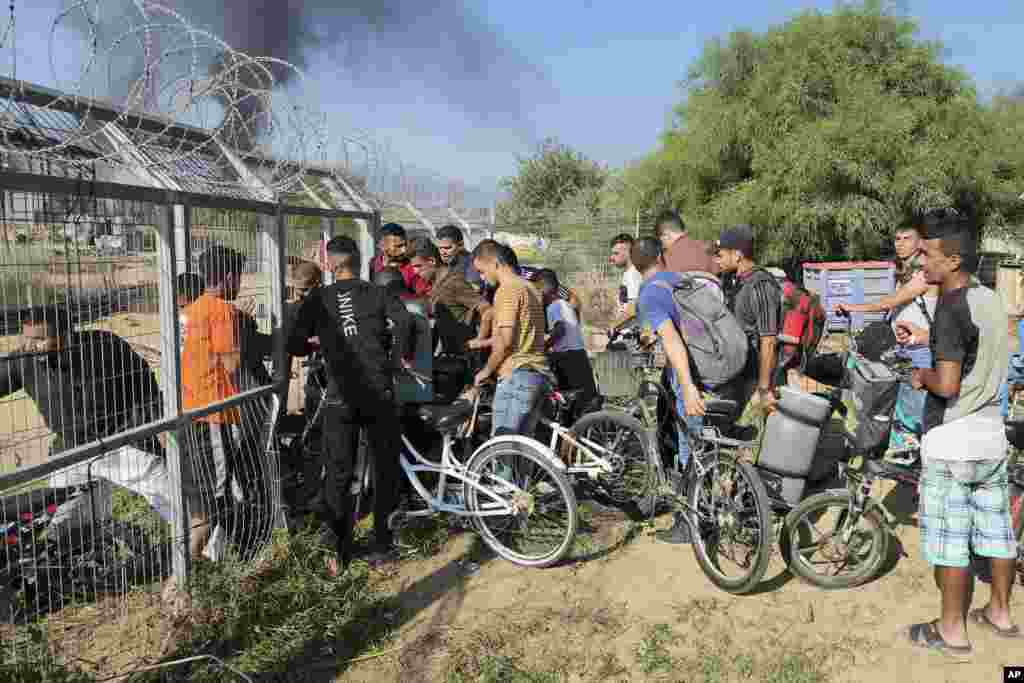 Palestinians from the Gaza Strip enter Kibbutz Kfar Azza, Israel, on Oct. 7, 2023. Hamas carried out an attack on Israel, firing thousands of rockets as Hamas fighters infiltrated the heavily fortified border in several locations.