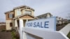FILE - A "for sale" sign is posted in front of a home in Sacramento, California, March 3, 2022.