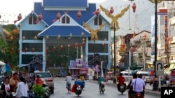 Sejumlah kendaraan bergerak melewati jembatan imigrasi yang mengarah ke Thailand di Tarchelik, negara bagian Shan, Myanmar, pada 21 Mei 2012. (Foto: AP/Khin Maung Win)