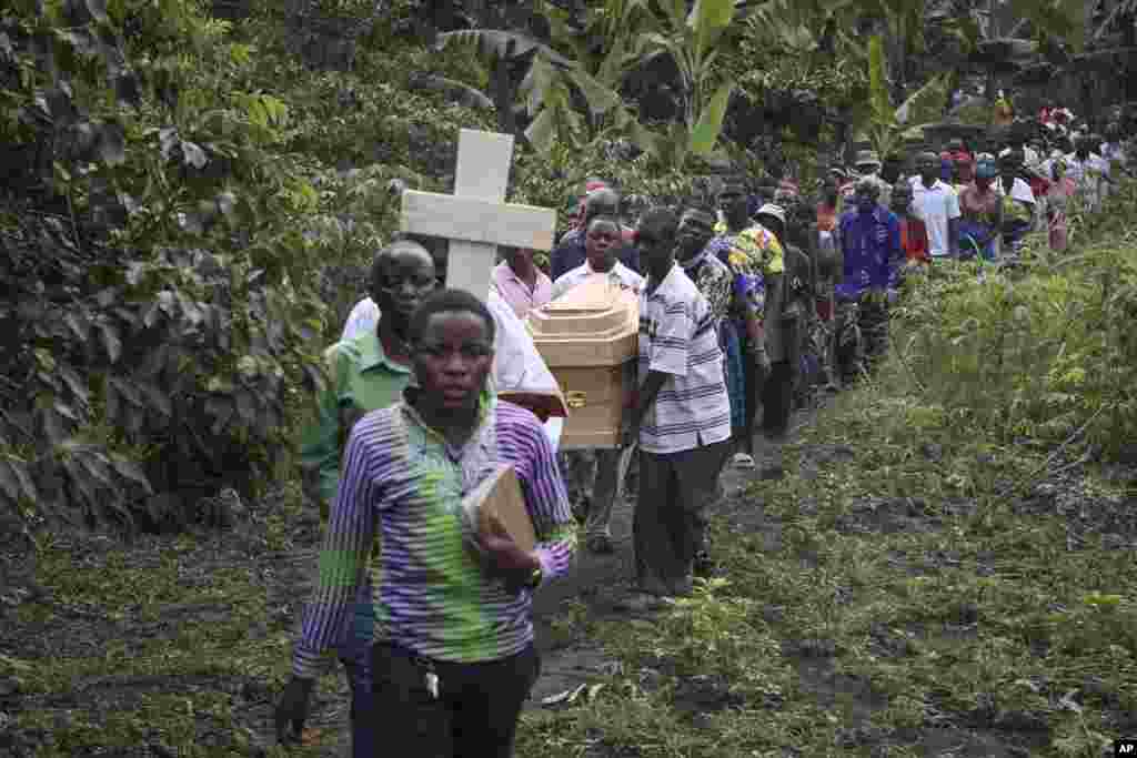 The coffins of Florence Masika and her son Zakayo Masereka, who were both killed by suspected rebels during the attack on the Lhubiriha Secondary School, are carried to their burial in Nyabugando, Uganda, June 18, 2023.