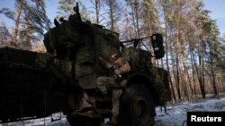 Seorang prajurit brigade artileri terpisah ke-45 Ukraina turun dari kokpit sistem howitzer self-propelled Archer buatan Swedia di hutan di wilayah Donetsk, di tengah serangan Rusia ke Ukraina, 16 Desember 2023. (Foto: REUTERS/Thomas Peter)