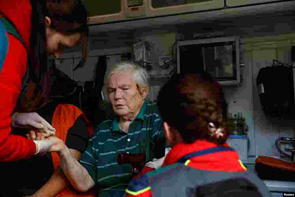 Los paramédicos ayudan a un residente local herido en el ataque aéreo ruso, en Járkov, Ucrania, el 22 de mayo de 2024. REUTERS/Valentyn Ogirenko