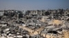 ARCHIVO - Personas caminan entre los escombros de edificios destruidos en Khan Yunis, Franja de Gaza, el 16 de abril de 2024. Es probable que los escombros de Gaza estén mezclados con municiones sin explotar, dicen expertos de la ONU en minas terrestres y explosivos.