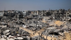 Orang-orang berjalan di antara puing-puing bangunan yang hancur akibat pemboman Israel di Khan Yunis, Jalur Gaza selatan, 16 April 2024. (AFP)