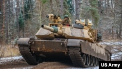 FILE - US soldiers operate a M1A1 Abrams during a training exercise at Bemowo Piskie, Poland, Nov. 25, 2022.