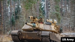 Soldados estadounidenses operan un tanque M1A1 Abrams durante un ejercicio de entrenamiento en Bemowo Piskie, Polonia, el 25 de noviembre de 2022.