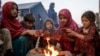 FILE — Displaced Afghan children warm themselves at a fire in a camp near the Torkham Pakistan-Afghanistan border crossing in Torkham, Afghanistan, Nov. 4, 2023, following their repatriation from Pakistan.