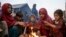 FILE - Afghan refugee children warm themselves near the Torkham Pakistan-Afghanistan border crossing in Torkham, Afghanistan, Nov. 4, 2023, after their repatriation from Pakistan. More than 800,000 Afghans are expected to return to Afghanistan this year; about half are children.