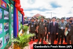 Cambodian Defense Minister Tea Banh, center left, and Chinese Ambassador to Cambodia Wang Wentian, center right, visit the site of the groundbreaking ceremony for a shipyard repairing and restoration workshop in Ream Cambodian Naval Base of Sihanoukville, June 8, 2022. (Cambodia's Fresh News via AP)