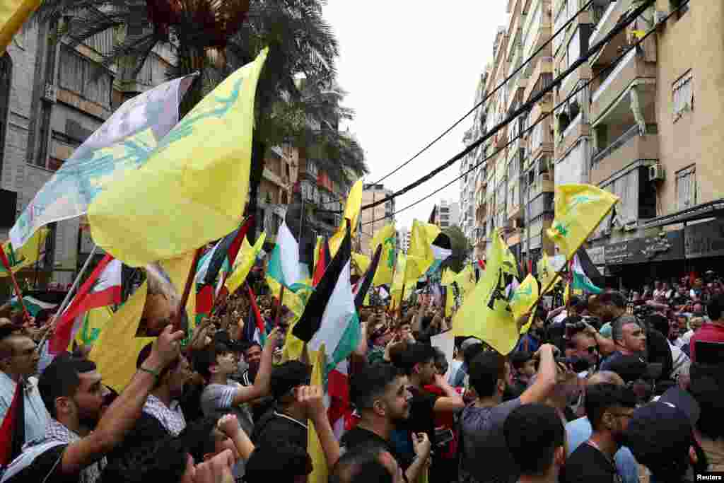 Supporters of Lebanon's Hezbollah carry flags during a rally to express solidarity with the Palestinians, in Beirut's southern suburbs, Oct. 8, 2023. 