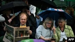 A man reads a newspaper displaying a picture of the newly elected Prime Minister Keir Starmer during a rain break at the 2024 Wimbledon Championships at The All England Lawn Tennis and Croquet Club in Wimbledon, southwest London, on July 7, 2024.