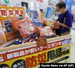 A person checks emergency kit sold at a shop following a strong earthquake in Shibushi, Kagoshima prefecture, southern Japan, on Aug. 9, 2024. (Kyodo News via AP)