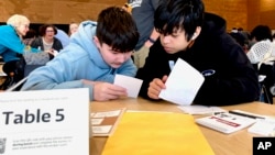 Meadowdale High School students Juanangel Avila, right, and Legacy Marshall work solve an exercise at MisinfoDay March 14, 2023, in Seattle.