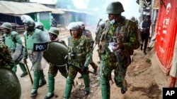 FILE - Riot policemen walk back during clashes with protesters in the Kibera area of Nairobi, Kenya, on July 19, 2023. Kenya has offered to lead an international police force aimed at combating Haiti's gang violence. 