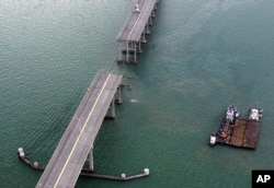 FILE - A section of the Queen Isabella Causeway is shown missing as crews break from their search and rescue due to a storm in Port Isabella, Texas, Sept. 15, 2001.
