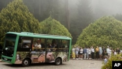 Tourists queue to catch a shuttle bus from Pena Palace