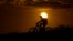 FILE - A cyclist tops a hill on a hot day at sunset, Aug. 20, 2023, in San Antonio. 