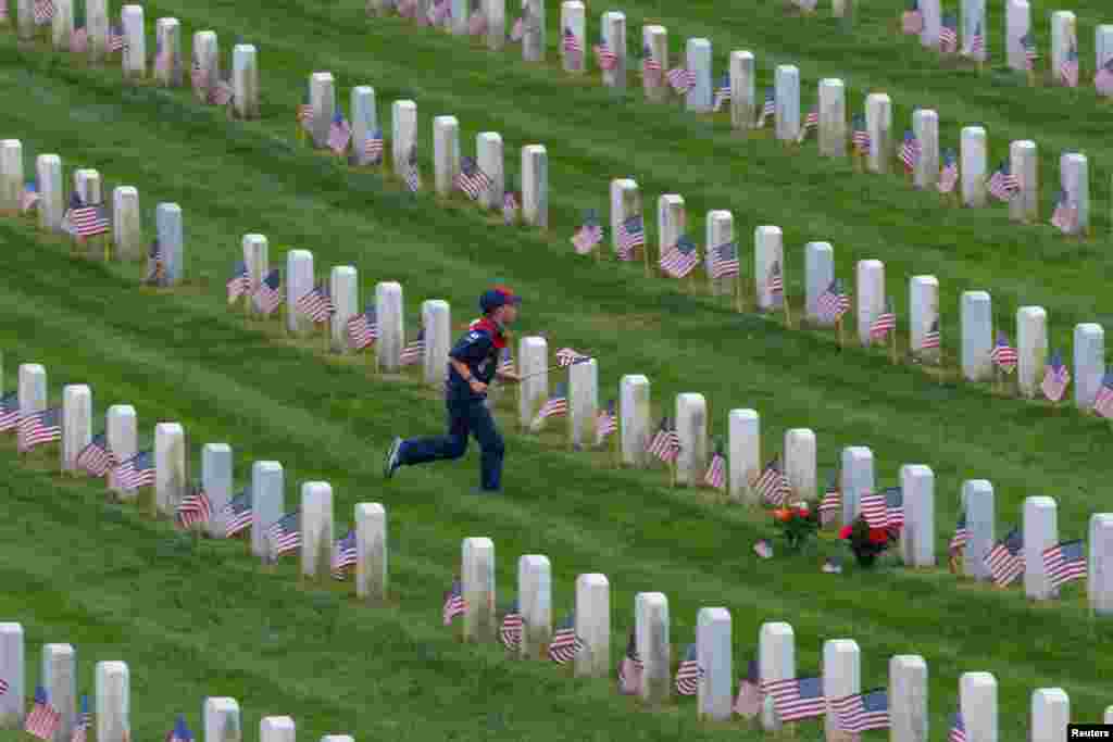 En el Cementerio Nacional Fort Rosecrans, en San Diego, California, un grupo de Boy Scouts pone banderas de Estados Unidos sobre las lápidas en preparación para los homenajes del Día de los Caídos.