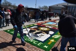 Inmigrantes guatemaltecos del Grupo Alfo Conce, originarios de Concepción, Quezaltenango, crean una alfonbra en el patio de la Catedral de St. Thomas, en Arlington. [Foto: Tomás Guevara, VOA]