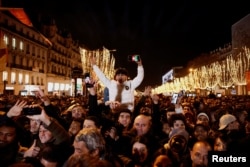Orang-orang berkumpul di jalan Champs Elysees saat perayaan Malam Tahun Baru dekat Arc de Triomphe di Paris, Prancis, 31 Desember 2023. (Foto: REUTERS/Benoit Tessier)