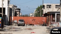 The bodies of inmates lie near a container used by the police to block a street following violent clashes that led to a prison break in Port-au-Prince, Haiti, March 3, 2024.