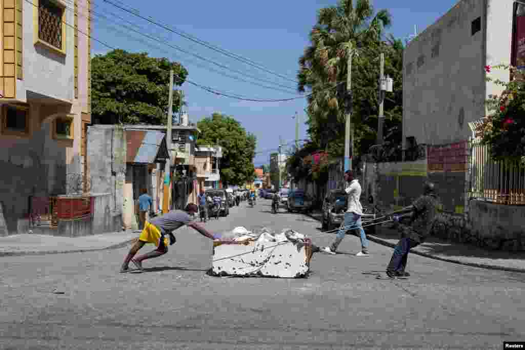 Men move a dead body inside an old refrigerator in Port-au-Prince, Haiti, June 30, 2024. REUTERS/Ricardo Arduengo