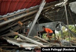 Seorang pria membongkar puing-puing rumahnya di Desa Malakopa, Kepulauan Mentawai, Sumatera Barat, 1 November 2010. (Foto: Reuters/Crack Palinggi)