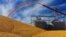 FILE - In this Sept. 23, 2015, photo, central Illinois farmers deposit harvested corn on the ground outside a full grain elevator in Virginia, Ill. 