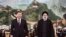 Iranian President Ebrahim Raisi, right, walks with Chinese President Xi Jinping 