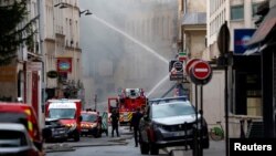 Petugas pemadam kebakaran Prancis berupaya memedamkan api kebakaran menyusul ledakan gas di pusat kota Paris, Prancis, 21 Juni 2023. (REUTERS/Gonzalo Fuentes)