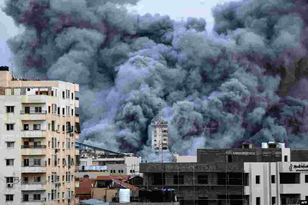 A plume of smoke rises above buildings in Gaza City on Oct. 7, 2023 during an Israeli airstrike that hit the Palestine Tower building. 