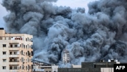 A plume of smoke rises above buildings in Gaza City on Oct. 7, 2023, after an Israeli airstrike.