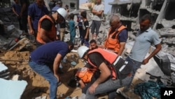 Palestinians search for survivors after an Israeli airstrike on a residential building in Nuseirat Refugee Camp, Gaza Strip, May 19, 2024. 