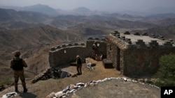 FILE - Pakistan Army troops observe the area from hilltop post on the Pakistan-Afghanistan border on Aug. 3, 2021.