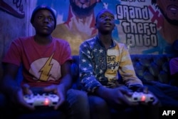 FILE - Teenagers play a video game at an arcade in Nairobi, Kenya, January 3, 2022.