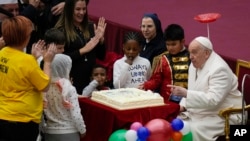 Pope Francis is offered a cake as he celebrates his birthday with children assisted by the Santa Marta dispensary during an audience in the Paul VI Hall, at the Vatican, Sunday, Dec. 17, 2023. Pope Francis turned 87 on Dec.17. 