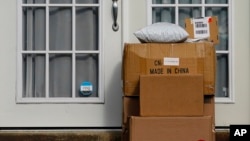 FILE - Packages, one labeled 'Made in China,' are seen stacked on the doorstep of a residence in Upper Darby, Pennsylvania, Oct. 27, 2021.