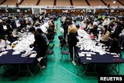 10일 한국 서울에서 열린 제22대 국회의원 선거에서 중앙선거관리위원회 관계자들이 투표 용지를 개표하고 있다.
