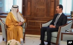 In this photo released by the official Facebook page of the Syrian Presidency, Syrian President Bashar Assad, right, meets with Saudi Arabia ambassador to Jordan Nayef al-Sadiri, in Damascus, May 10, 2023. (Syrian Presidency Facebook page via AP)