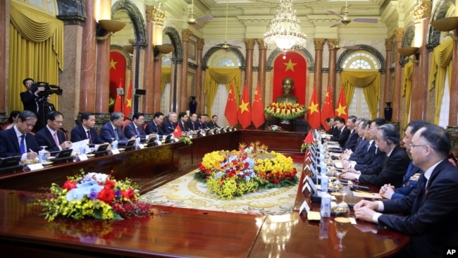 FILE - Vietnamese President Vo Van Thuong, sixth left, and Chinese President Xi Jinping, eighth right, meet at the Presidential Palace in Hanoi, Vietnam, on Dec. 13, 2023.