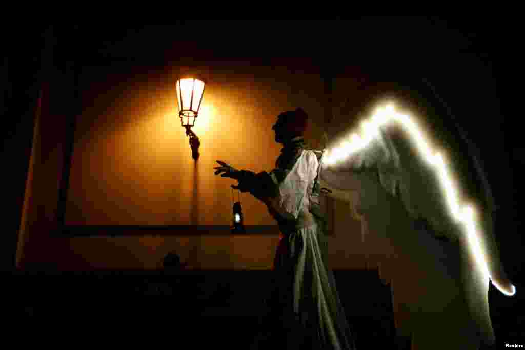 A man dressed as an angel walks through a street as a part of Christmas celebrations in Prague, Czech Republic.