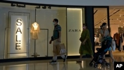 FILE - A man with a shopping bag leaves a ZARA flagship store at a mall in Bejing, June 21, 2023. Foreign companies are shifting investments and their Asian headquarters out of China as confidence in the business climate drops.