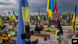 Seorang perempuan mengunjungi makam temannya, seorang prajurit Ukraina, di pemakaman Kryvyi Rih di Ukraina timur, 23 April 2023. (Foto: AP)