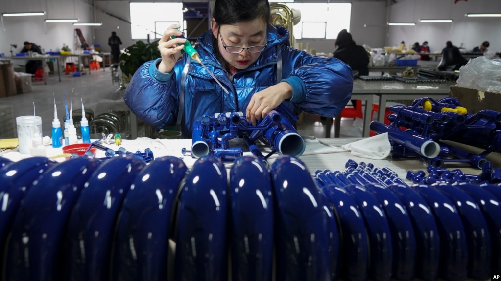 2023年2月23日一名工人在河北省武强县的一家制造厂组装西洋乐器(photo:VOA)