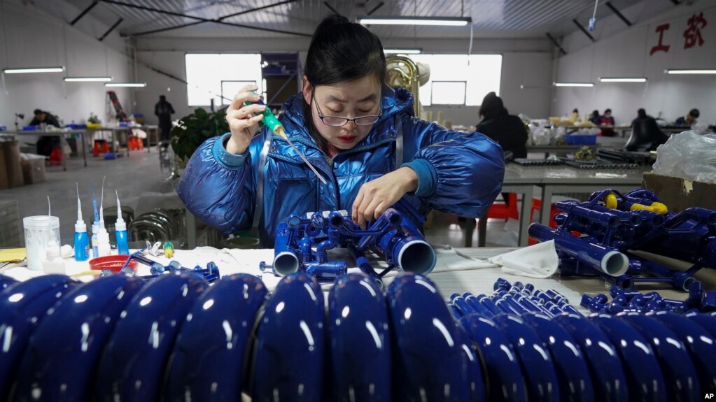 新华社2023年2月23号发表的照片显示，中国河北省武强县一家工厂的工人正在装配一种西方乐器。中国工厂的生产活动从今年2月开始逐渐增速。(photo:VOA)