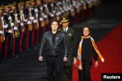 El presidente de Argentina, Javier Milei, junto a la ministra de RREE de El Salvador, Alexandra Hill Tinoco, a su llegada para participar en la ceremonia de toma de posesión del segundo mandato del presidente Nayib Bukele, en San Luis Talpa, El Salvador, el 31 de mayo de 2024.