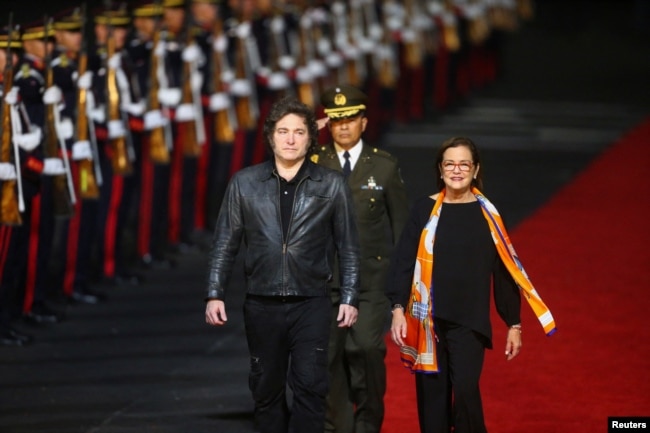 El presidente de Argentina, Javier Milei, junto a la ministra de RREE de El Salvador, Alexandra Hill Tinoco, a su llegada para participar en la ceremonia de toma de posesión del segundo mandato del presidente Nayib Bukele, en San Luis Talpa, El Salvador, el 31 de mayo de 2024.